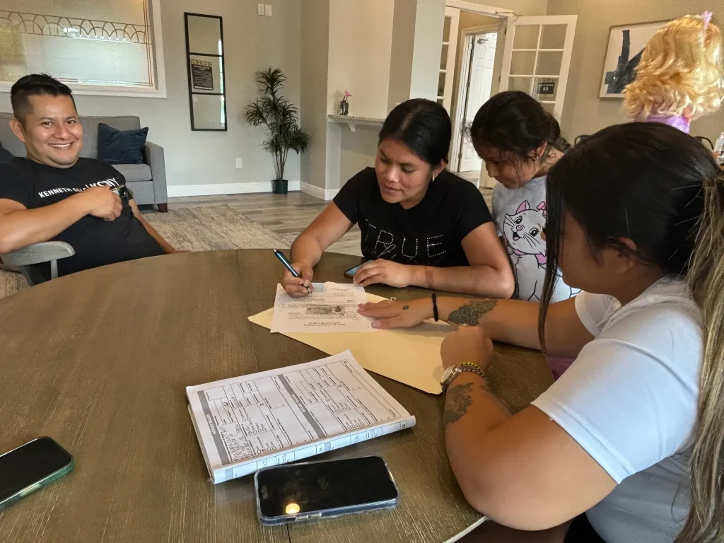 A group of people signing documents and notarizing signatures.