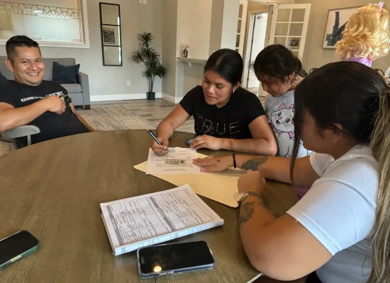 A group of people signing documents and notarizing signatures.