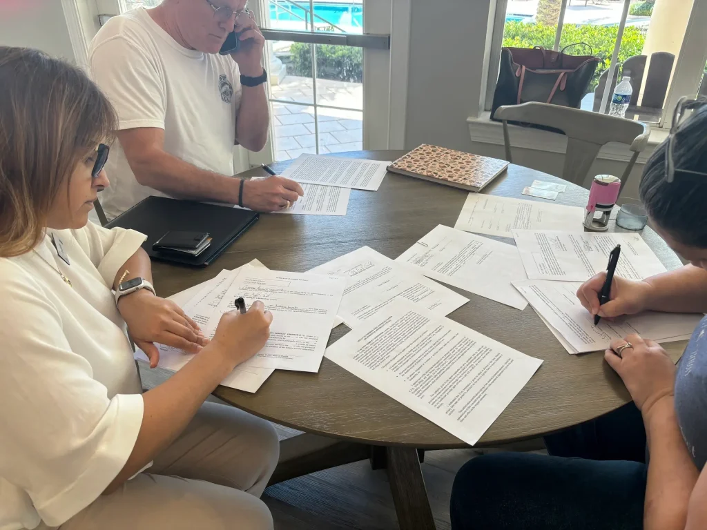 A group of family members signing and witnessing legal documents with a mobile notary in Florida.