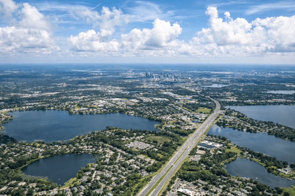 Aerial view of Central Florida showing lakes, neighborhoods, and highways under a partly cloudy sky