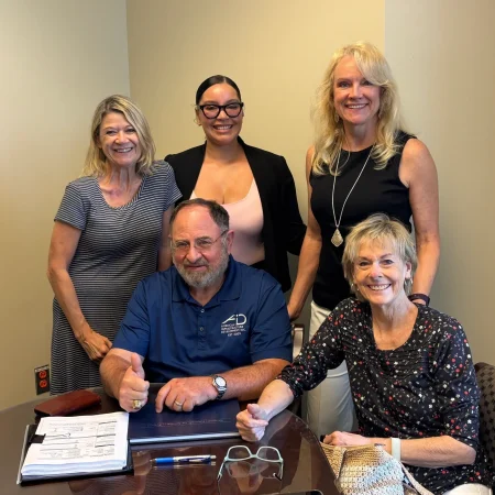 A group of people gathered for mobile notary services in Florida, signing and witnessing legal documents.