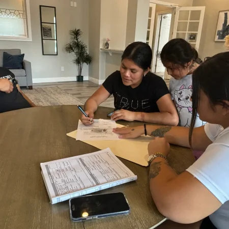 A group of people signing documents and notarizing signatures.