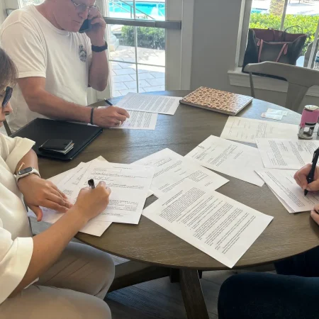 A group of family members signing and witnessing legal documents with a mobile notary in Florida.
